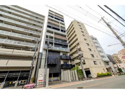 two tall buildings on a city street with a crane at ZOOM Esaka Park - Vacation STAY 17110 in Suita
