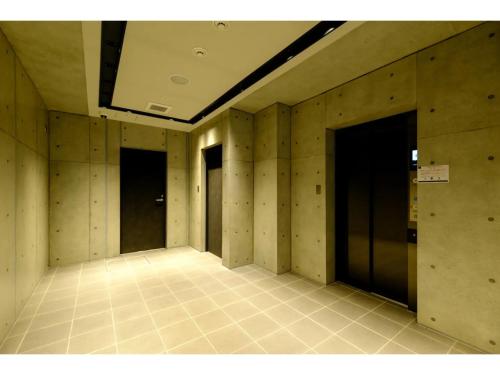 an empty hallway with four doors and a tile floor at ZOOM Esaka Park - Vacation STAY 17110 in Suita