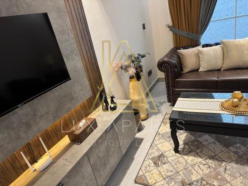 a living room with a couch and a tv at Lux Aparts Holiday Home Citi Housing Jhelum in Jhelum
