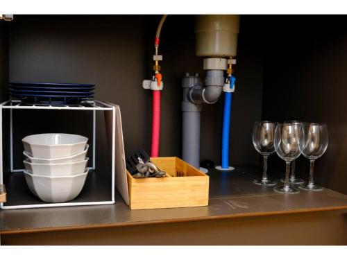 a counter with wine glasses and a box on a shelf at ZOOM Esaka Park - Vacation STAY 17111 in Suita