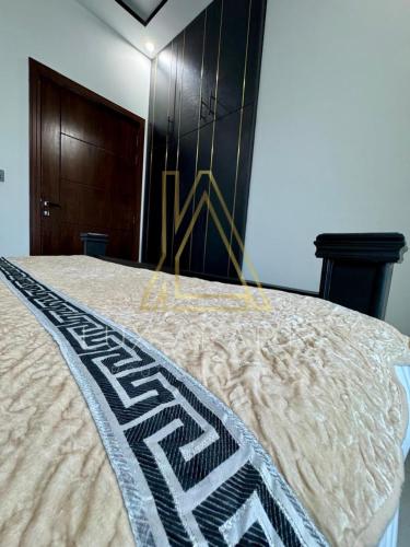 a bed with a blanket on top of it at Lux Aparts Holiday Home Citi Housing Jhelum in Jhelum