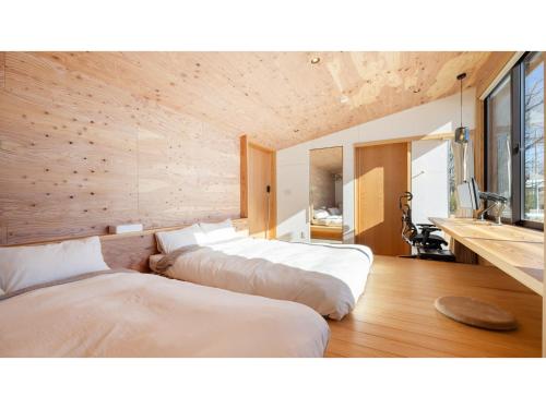 two beds in a room with wooden walls at Mori de Waoke Nasuppo - Vacation STAY 23918v in Nasu-yumoto