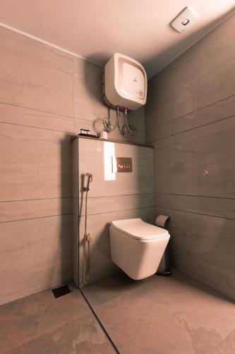 a bathroom with a toilet and a tv on the wall at Sumitel Sanderling 500 meters from Mall Road in Darjeeling