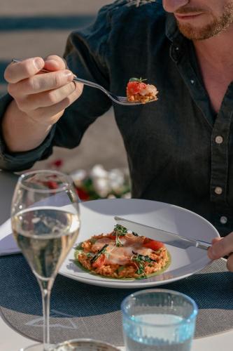a man eating a plate of food on a table at Astoria Resort in Riva del Garda