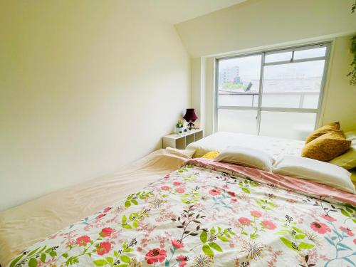 a bedroom with a large bed with a window at Sakura Apartment - Vacation STAY 17197 in Toyonaka