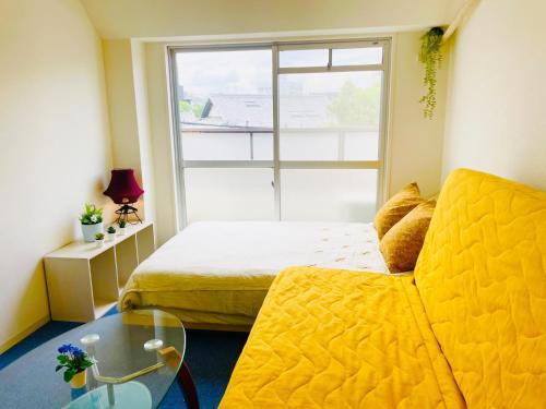 a small room with a bed and a glass table at Sakura Apartment - Vacation STAY 17197 in Toyonaka