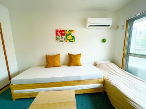 a bedroom with two beds and a window at Sakura Apartment - Vacation STAY 17193 in Toyonaka