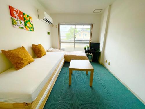 a room with two beds and a table in it at Sakura Apartment - Vacation STAY 17193 in Toyonaka