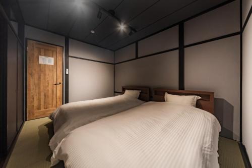 a bedroom with a large bed and a wooden door at villa-rizo midorigaoka - Vacation STAY 17519 in Takayama