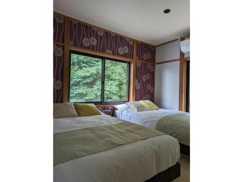 two beds in a room with a window at Shinra - Vacation STAY 29374v in Ise