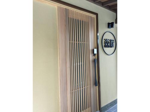 a wooden door in a hallway with a clock on the wall at Shinra - Vacation STAY 29374v in Ise