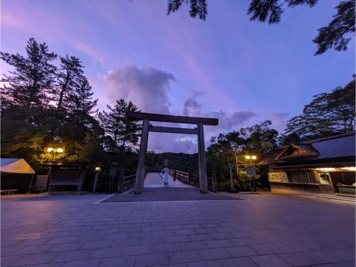 a person standing in front of a torii gate at night at Shinra - Vacation STAY 29374v in Ise