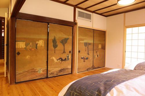 a bedroom with a painting on the wall at AsukanoMahoroba Hanare - Vacation STAY 17240 in Asuka