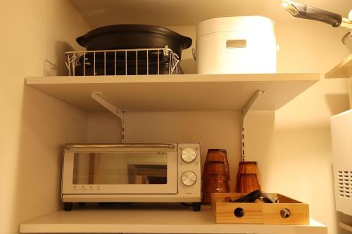 a microwave sitting on a shelf in a kitchen at AsukanoMahoroba Hanare - Vacation STAY 17240 in Asuka