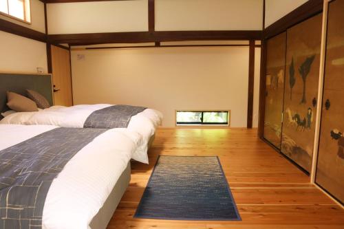 a bedroom with two beds and a rug at AsukanoMahoroba Hanare - Vacation STAY 17240 in Asuka