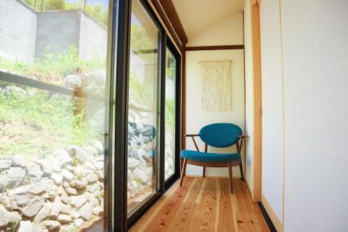 a room with a window and a blue chair at AsukanoMahoroba Hanare - Vacation STAY 17240 in Asuka
