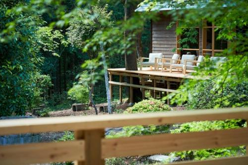 a wooden deck with white chairs and a cabin at THEIR SATOYAMA FIELD - Vacation STAY 29945v in Kurobane