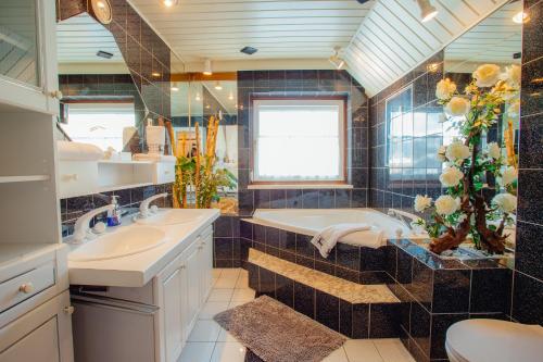a bathroom with two sinks and a tub and a toilet at Appartement SEPPI by MoniCare (Haus Claudia) in Seefeld in Tirol