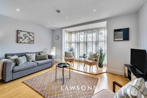 a living room with a couch and a tv at Town Centre Living by Lawsons with free parking in Windsor