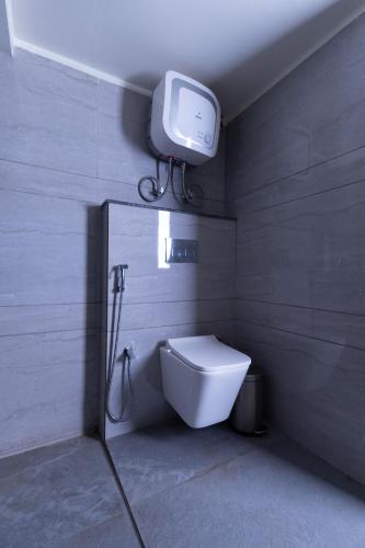 a bathroom with a toilet and a tv on the wall at Sumitel Sanderling 500 meters from Mall Road in Darjeeling