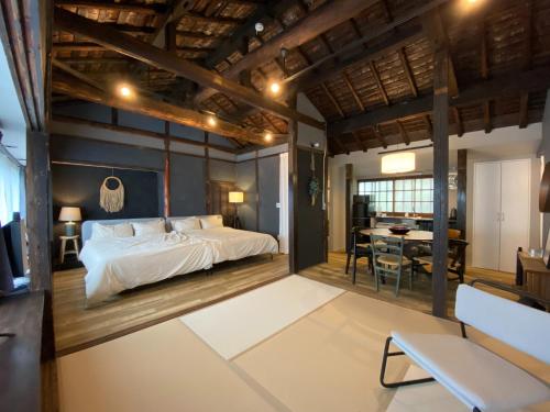 a bedroom with a large bed and a dining room at Nagasaki Sakayado OKU - Vacation STAY 35113v in Nagasaki