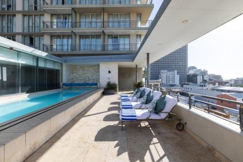 a balcony with lounge chairs and a pool on a building at Pepperclub Hotel in Cape Town