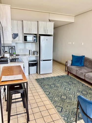 a kitchen and living room with a couch and a table at Durban Point Waterfront, 505 Quayside 40 Canalquay Rd in Durban