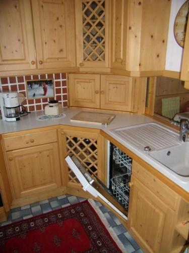 a kitchen with wooden cabinets and a sink and an oven at Haus Lundsör-Barret by MoniCare in Seefeld in Tirol