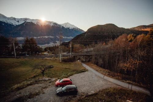 two cars parked on a gravel road in the mountains at Appartement RUDI by MoniCare in Reith bei Seefeld