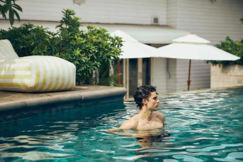 a man swimming in a swimming pool at The Davis Bangkok in Bangkok