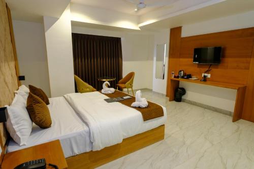 a hotel room with a bed and a television at Hotel Sterling Executive in Navi Mumbai