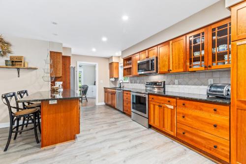 a large kitchen with wooden cabinets and a table at New!! Pool Vibes At Vanishing Run in Harwood