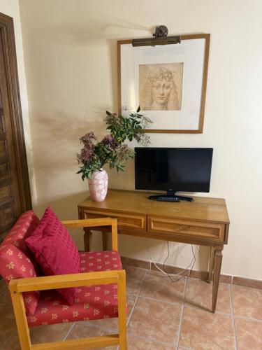 ein Schreibtisch mit einem Fernseher und einem Stuhl in einem Zimmer in der Unterkunft Hotel Boutique Cumbres de Castilla in Mandayona