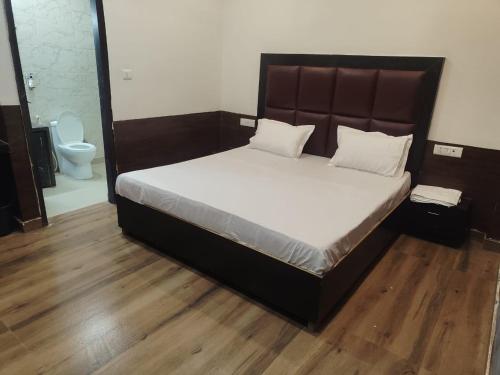 Cama grande en habitación con aseo en HL Residency Near Expo Mart Centre, en Greater Noida