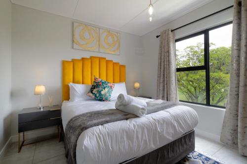 a bedroom with a large bed and a large window at #AlimamaSpaces Jade's Greenlee in Sandton