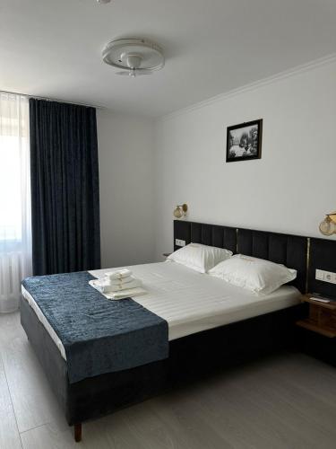 a bedroom with a large bed with white sheets at Турист in Astana