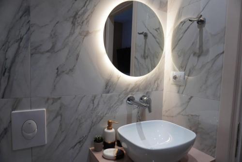 a bathroom with a white sink and a mirror at Ionian Blue Apartament 4 in Himare