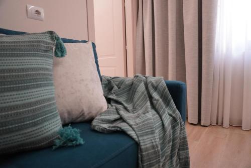 a blanket sitting on a blue couch with a pillow at Ionian Blue Apartament 4 in Himare