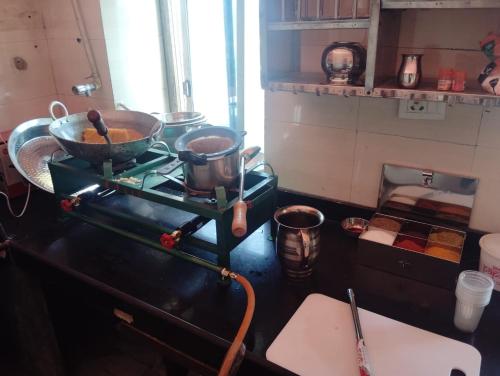 a kitchen with two pots and pans on a stove at Keru Guest House City Centre in Jodhpur