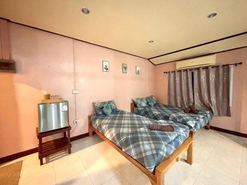 a room with two beds and a tv in it at Wangsarai Resort and Restaurant วังสาหร่าย รีสอร์ต และ ร้านอาหาร in Don Sak