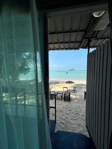 a view of the beach from a building with an open window at Wangsarai Resort and Restaurant วังสาหร่าย รีสอร์ต และ ร้านอาหาร in Don Sak