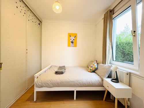 a small bedroom with a bed and a window at Lovely Maindoor flat at Murrayfield with Gardens in Edinburgh