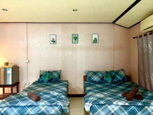 a bedroom with two beds and a table at Wangsarai Resort and Restaurant วังสาหร่าย รีสอร์ต และ ร้านอาหาร in Don Sak