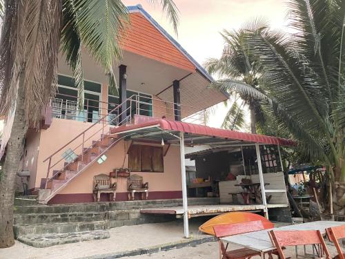 a house with a balcony and a table and chairs at Wangsarai Resort and Restaurant วังสาหร่าย รีสอร์ต และ ร้านอาหาร in Don Sak