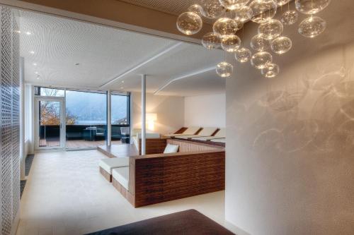 a living room with a bed and a chandelier at Seehotel Waldstätterhof Swiss Quality in Brunnen