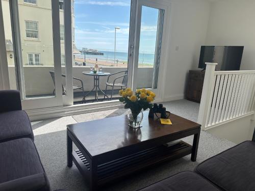 a living room with a vase of flowers on a coffee table at House by the Sea, Worthing in Worthing