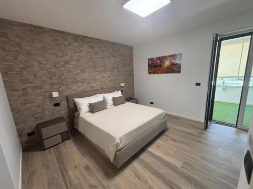 a bedroom with a bed and a brick wall at B&B Bari Apartment by Margi in Bari