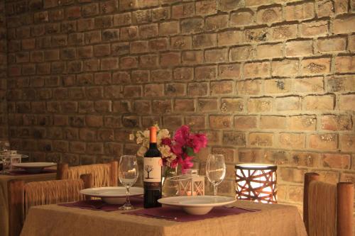 a table with a bottle of wine and glasses at Bamboo Lodge Paracas in Paracas