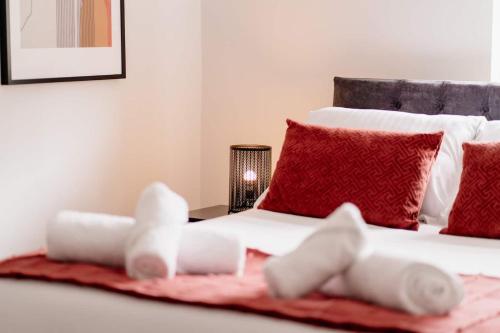 a bedroom with a white bed with red pillows at Modern Skipton House, Sleeps 5, Canal & Parking in Skipton