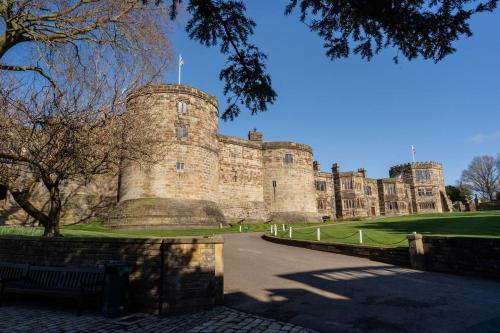 a large castle with a bench in front of it at Stylish Skipton 3 Bed, WIFI, Dog Friendly, Walks in Skipton